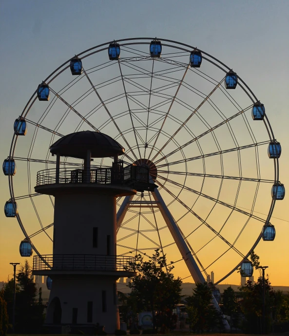 the large ferris wheel is on the top of a light house