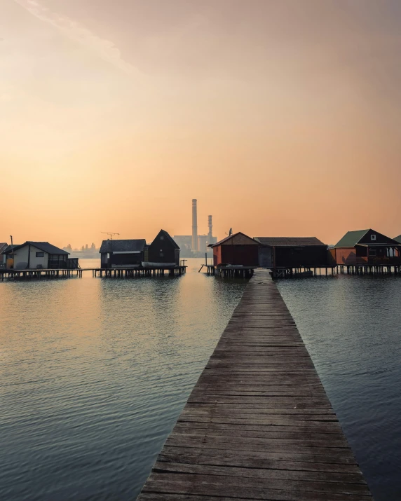 the dock leads to several wooden homes on water