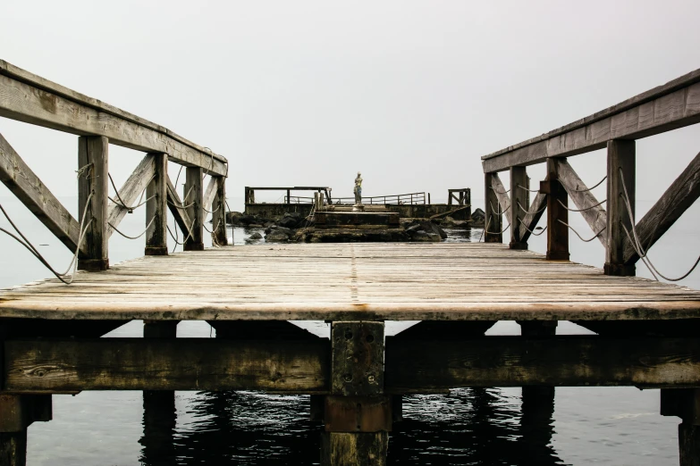 a wooden pier in the middle of some water