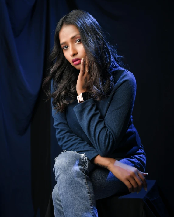 a girl sitting on top of a black chair