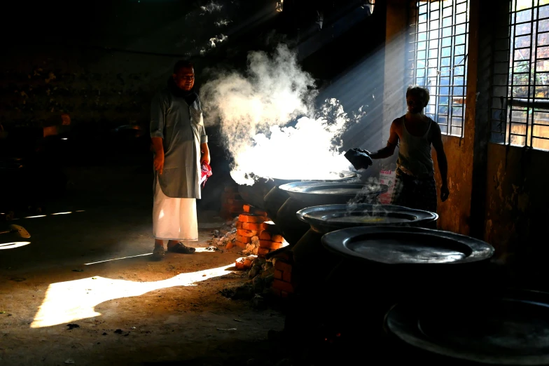 there are two men preparing food in the kitchen