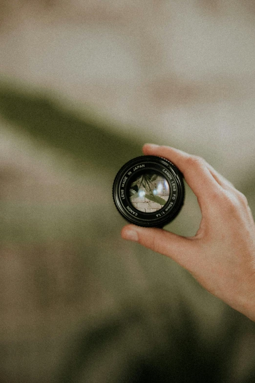 a close up of a person holding a camera lens