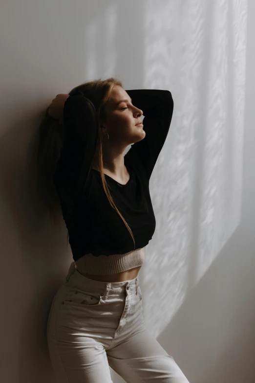 a woman poses for a po against a wall