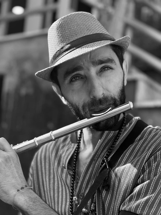 a man holding a flute with a hat on it