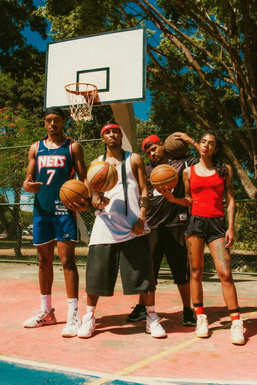 a group of young people holding basketballs on top of a court