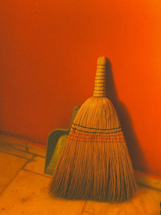 a broom laying on a floor next to a wall