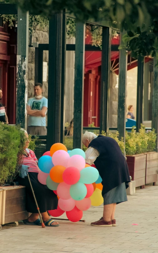 two people are looking at the balloons on the ground