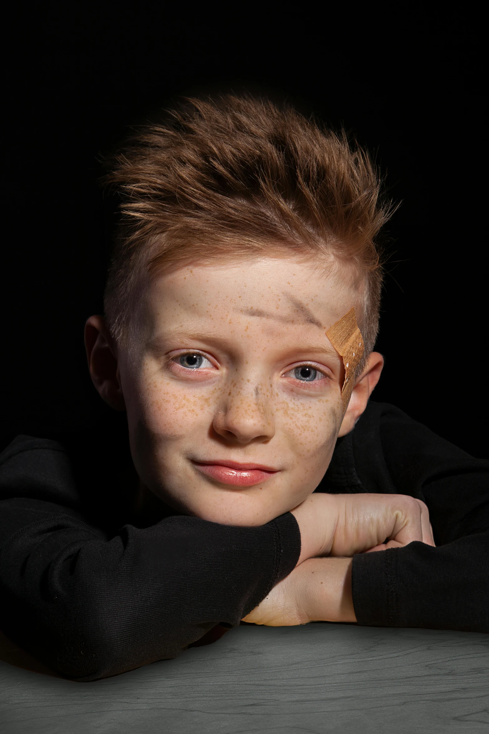 a  wearing a black shirt is posing with his hands under his chin