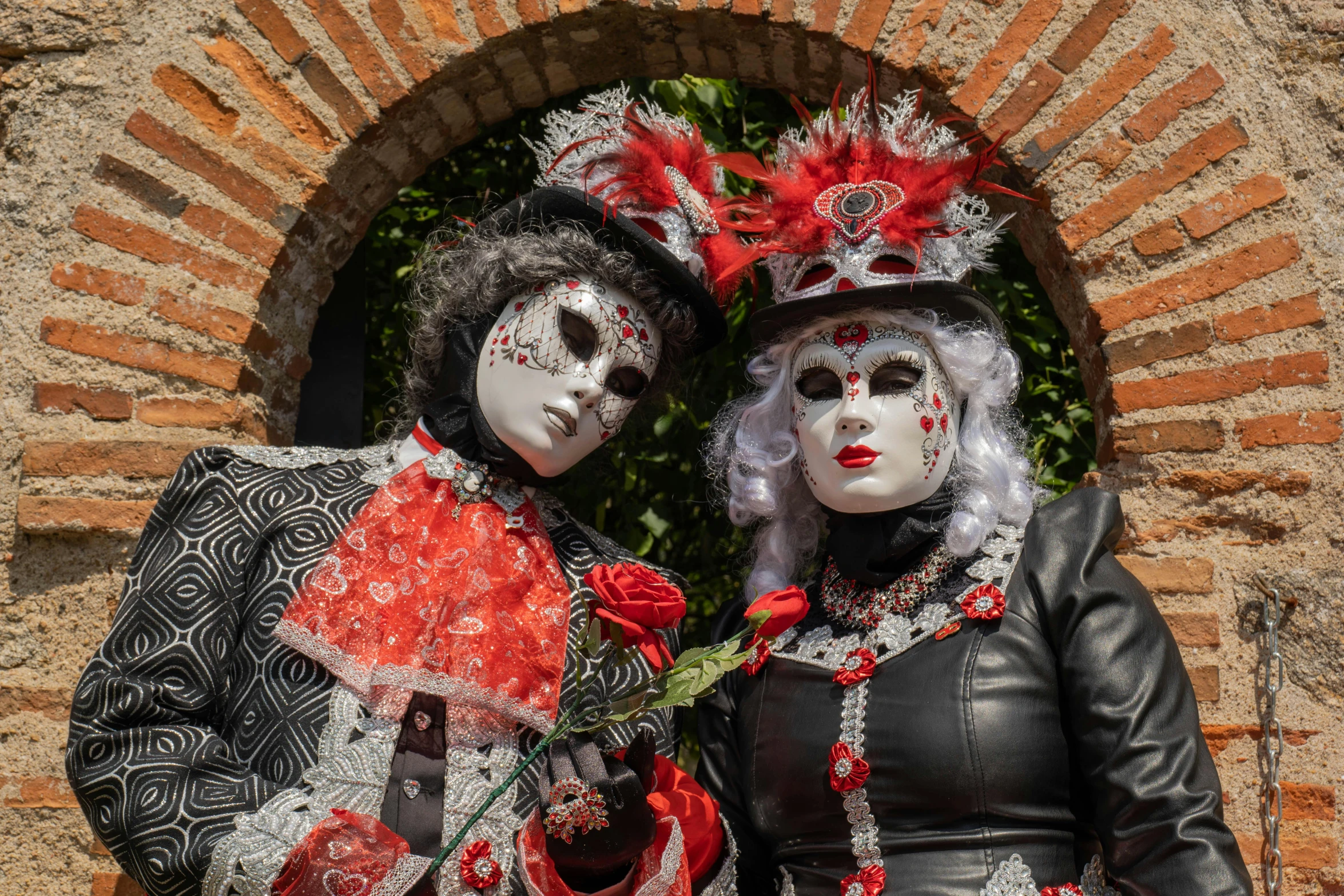 two people wearing black, red and white masks