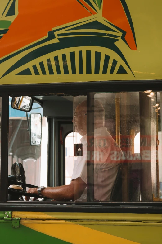 a man is sitting at the wheel of a bus