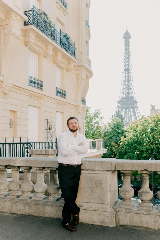 the man in the suit is leaning against a rail