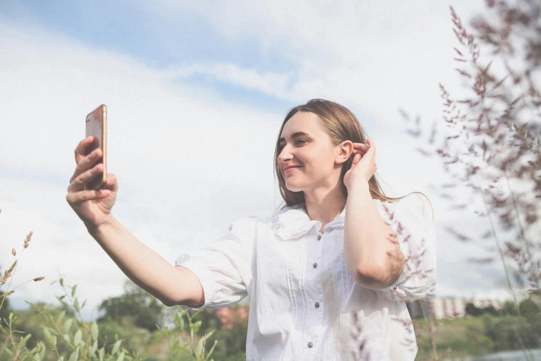 a woman holds her phone up to take a po