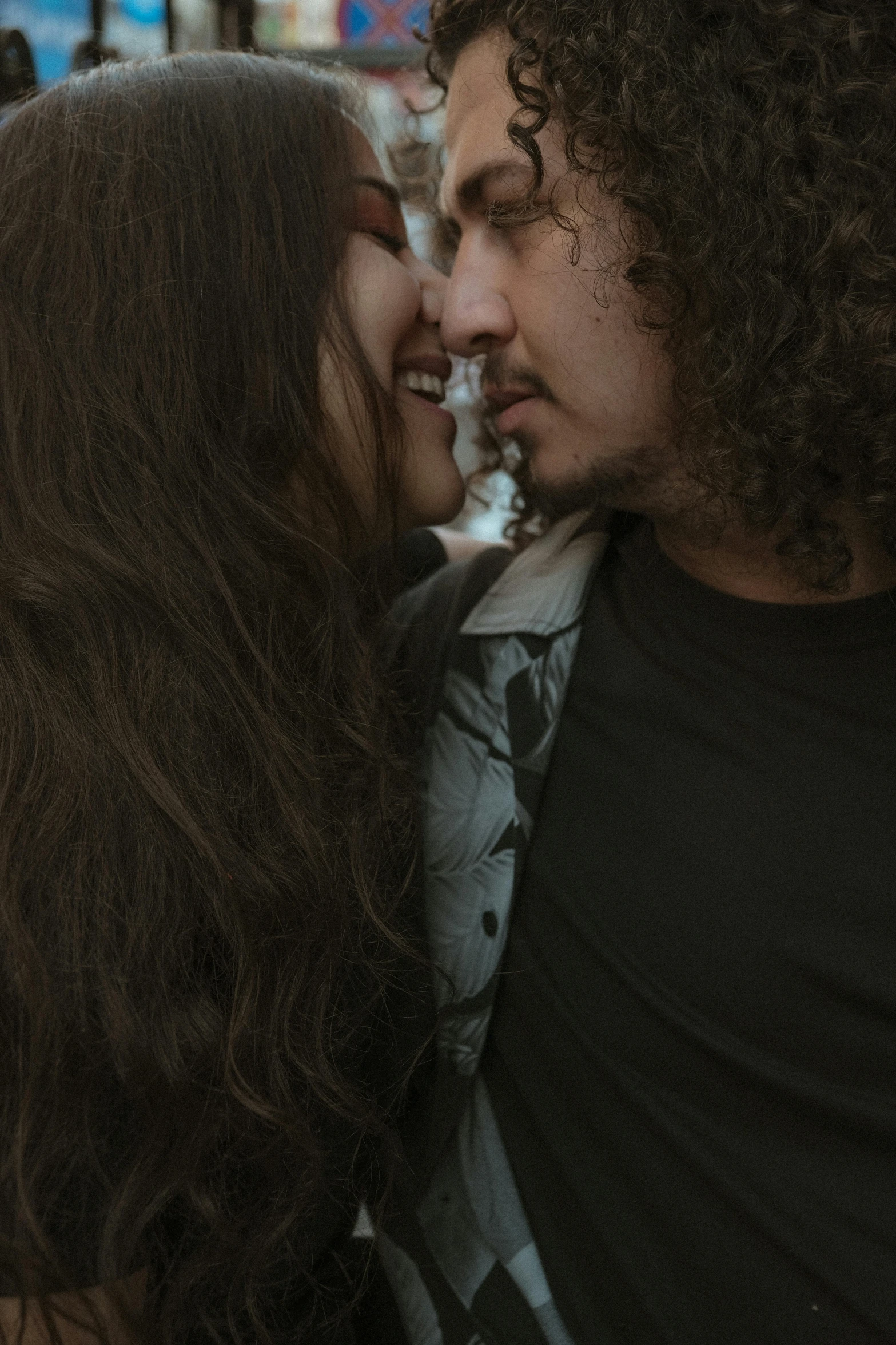 a woman is kissing a man with long hair