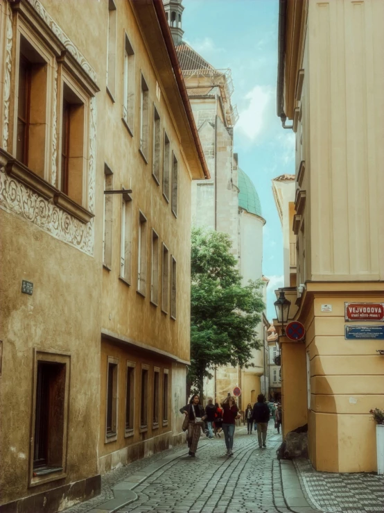 a cobblestone road with many people walking along it