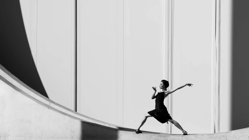 woman doing dancing in black dress near a large building