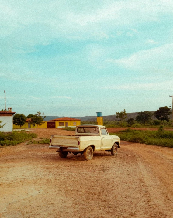 an old pick up truck parked on a dirt road