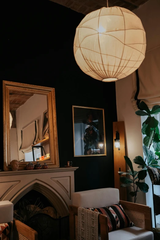 a small living area is furnished with white chairs and a white fireplace mantel