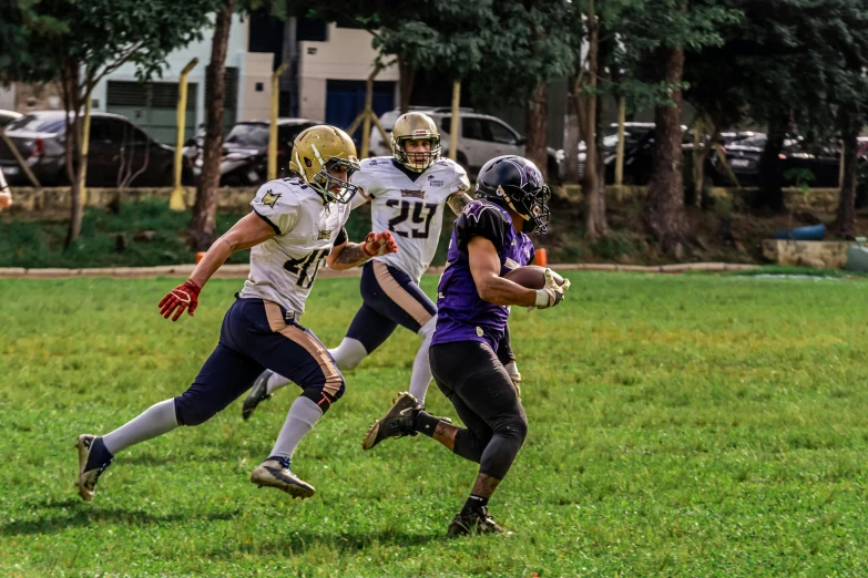 two football players running and holding the ball