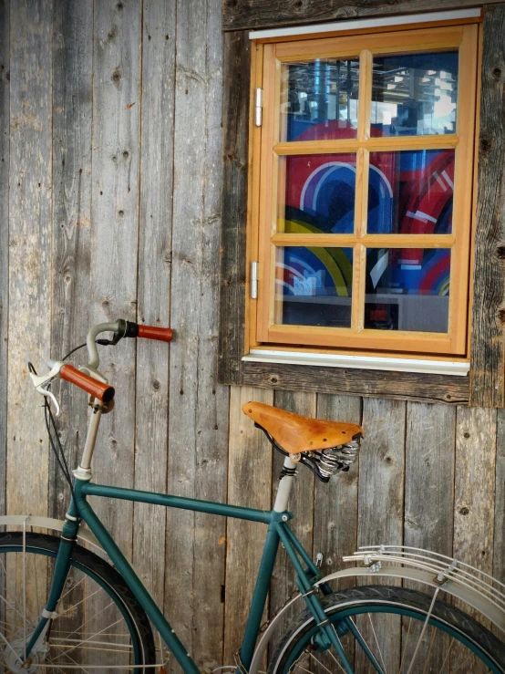 a bicycle is parked next to a wooden building with a window