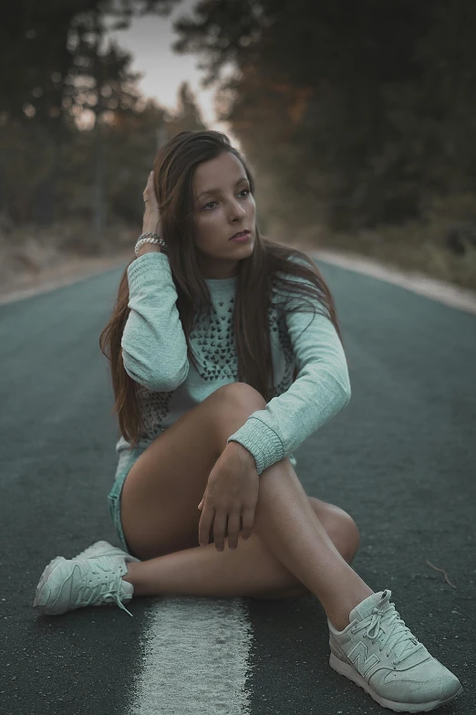 a woman sitting on the ground talking on her cell phone