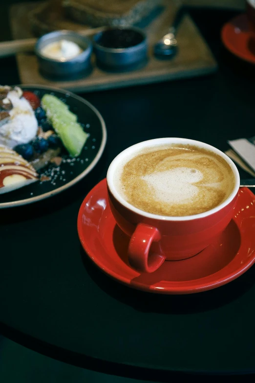 coffee sits next to a plate with a cake