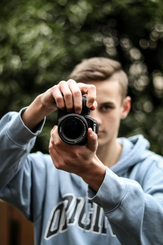 a man holding a camera to take pictures