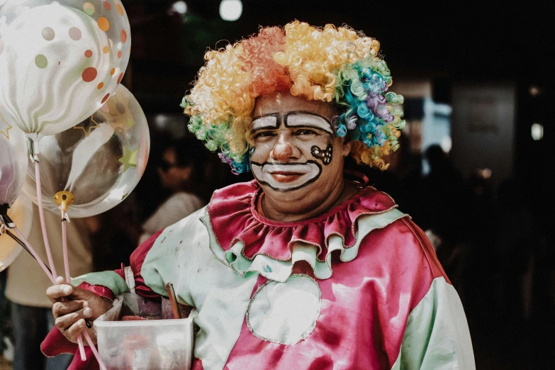 a clown holding a cup in his hand