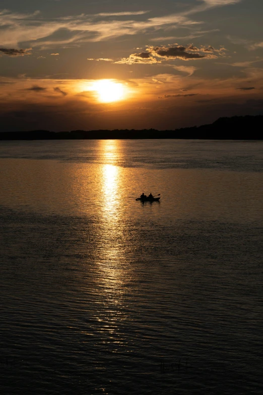 a couple of boats are in the water at sunset