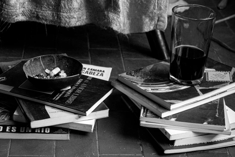 there are many books and a glass of drink on this table