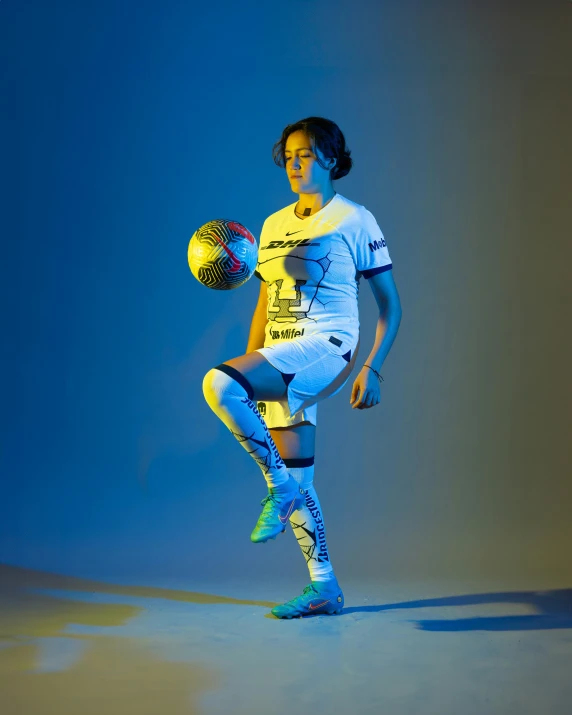 a girl wearing soccer attire holding a ball