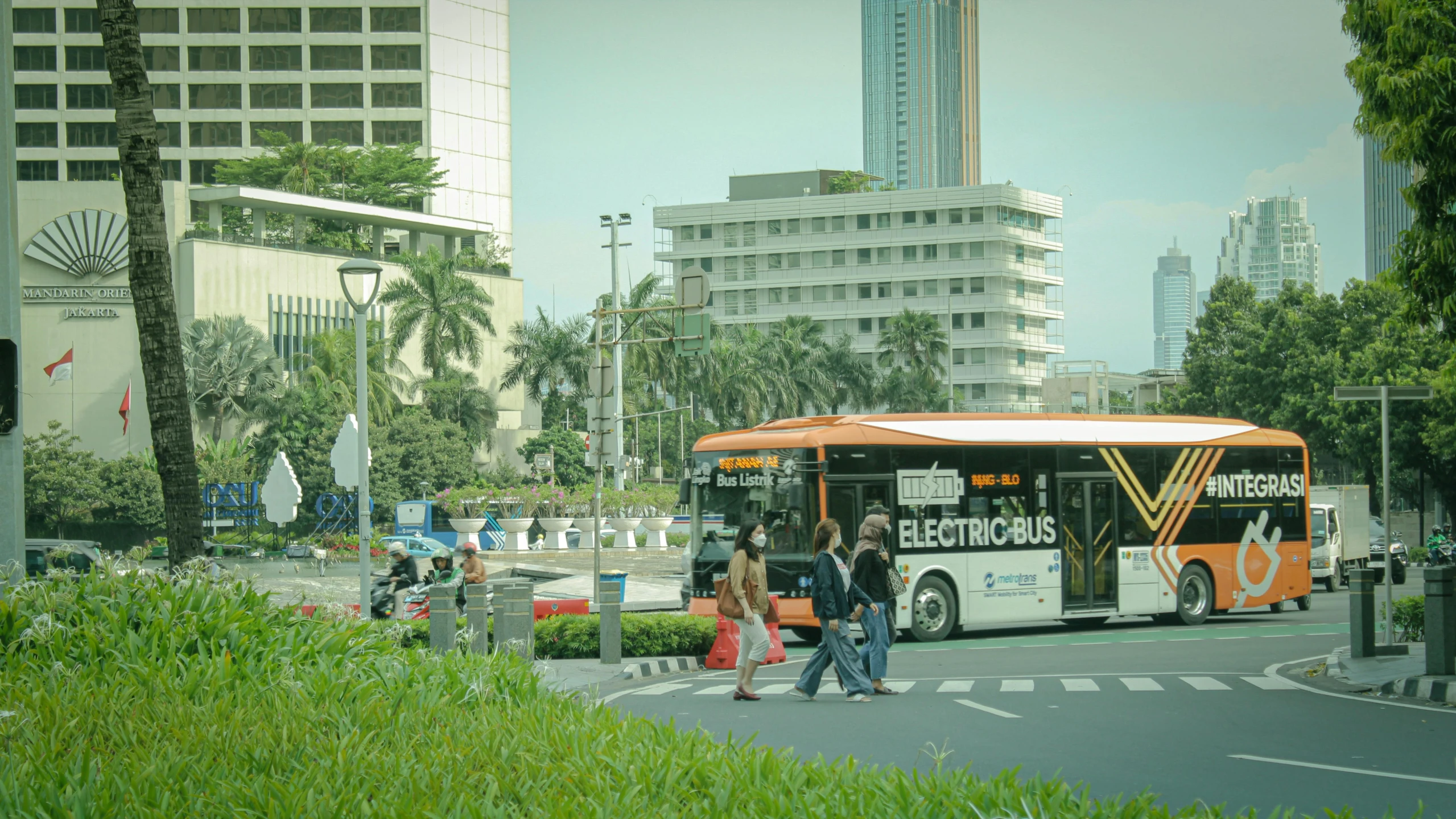 people are walking towards a bus at the intersection