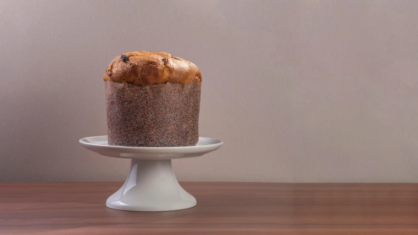 a cake sitting on a cake plate on a wooden table