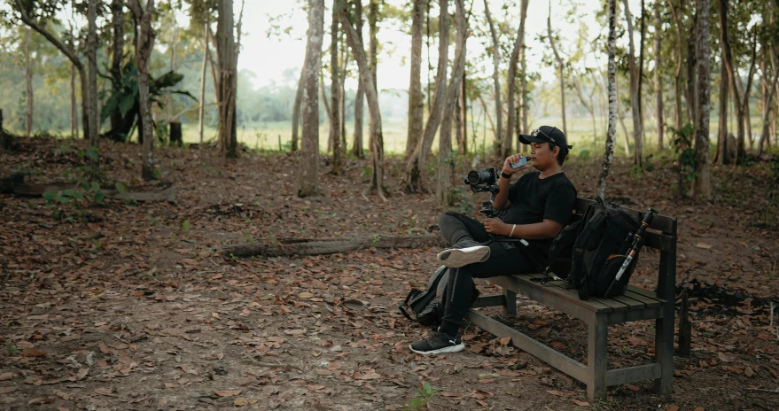 man sitting on a wooden bench in the woods