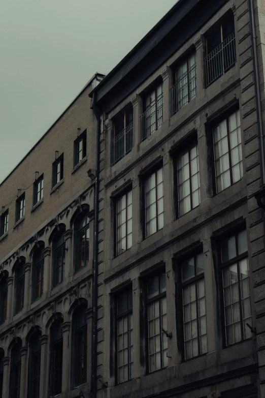 the brown building has many windows on each of its sides