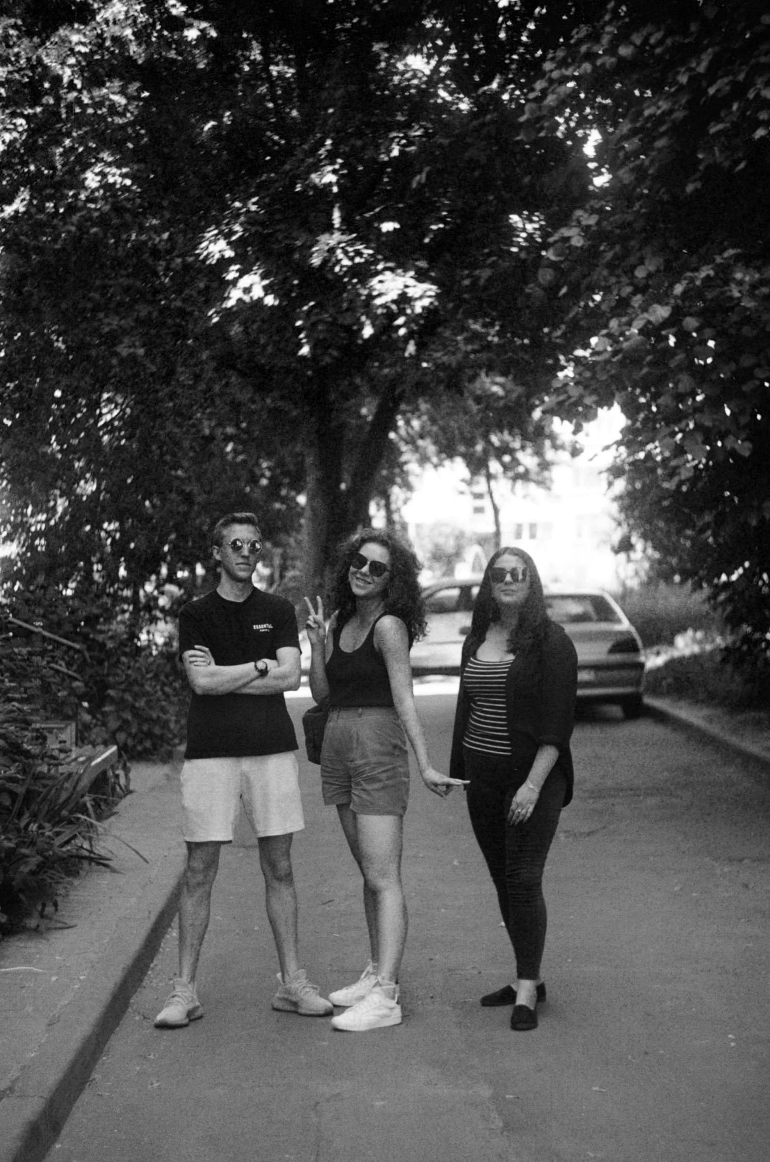 three young women are on the sidewalk in black and white