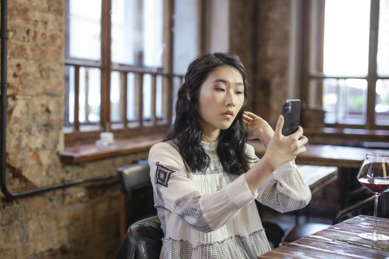 an asian girl looking at her phone in a restaurant