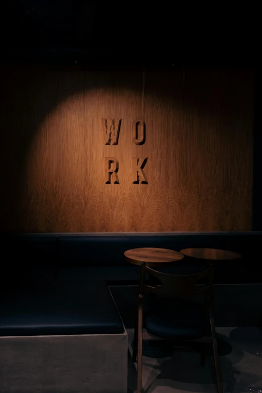 a chair and a table lit up with the word love written in a dark room