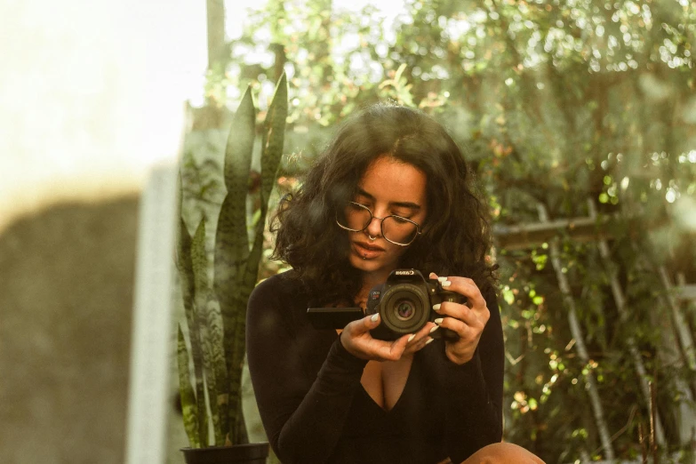 a woman in glasses taking a po with her camera