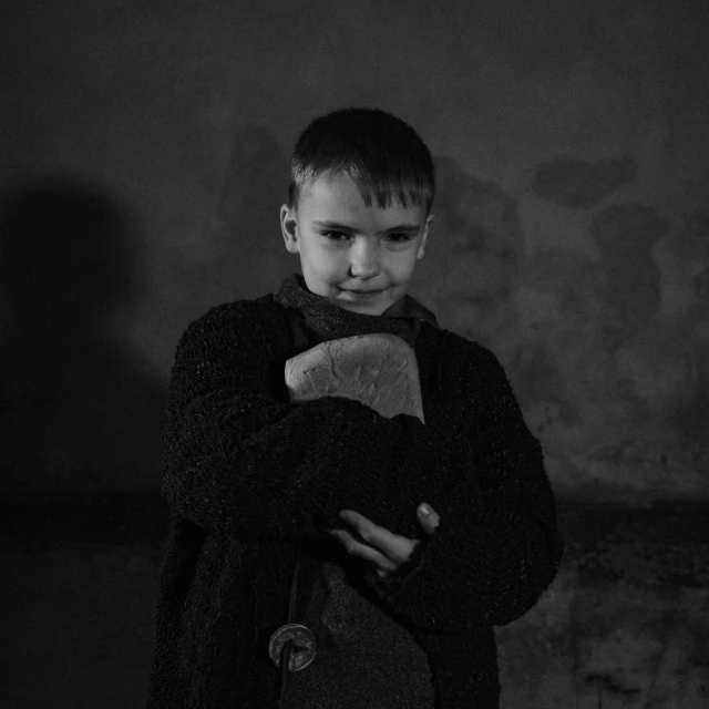 a boy holding a stuffed toy and smiling