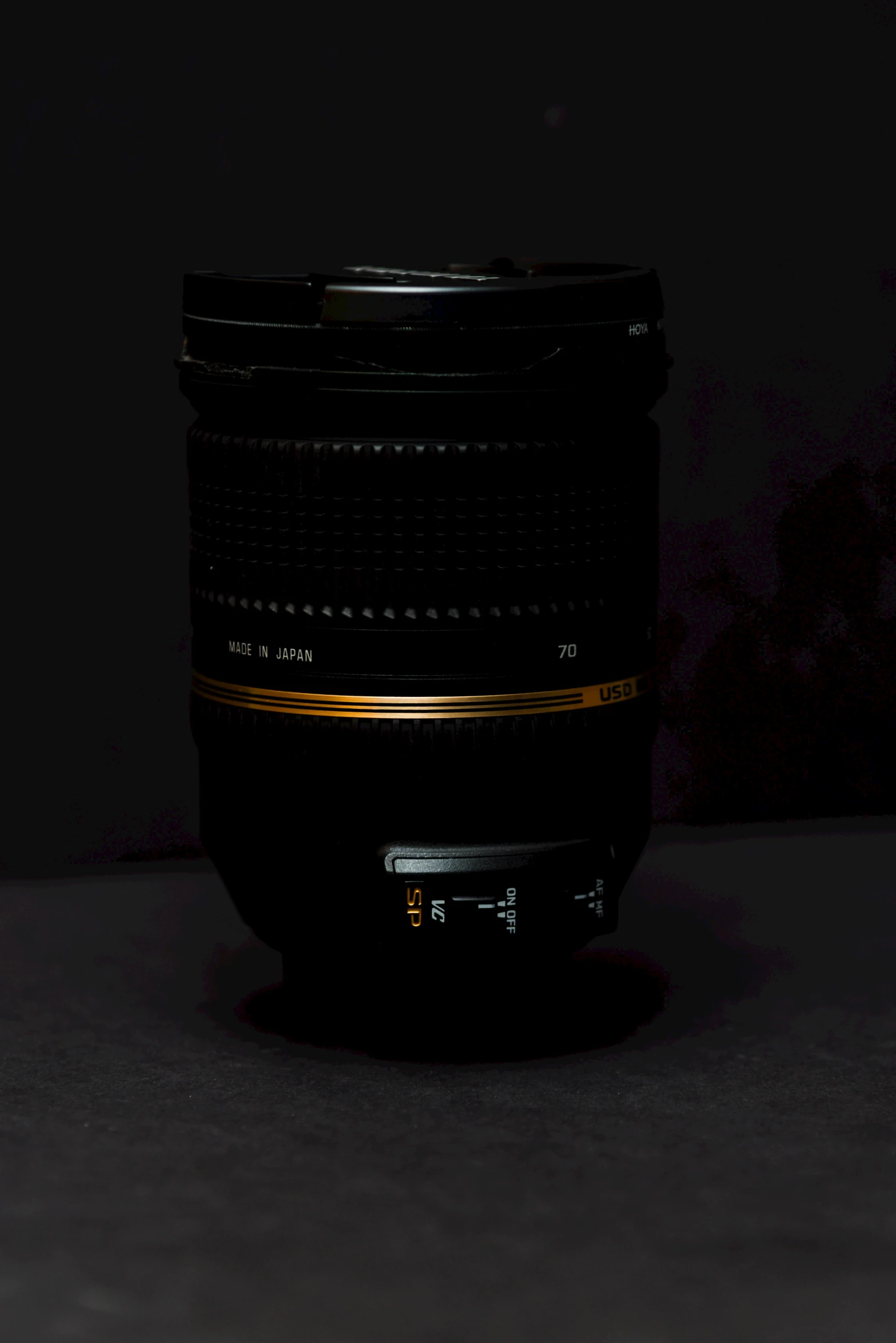 a black canon lens with gold stripes on it