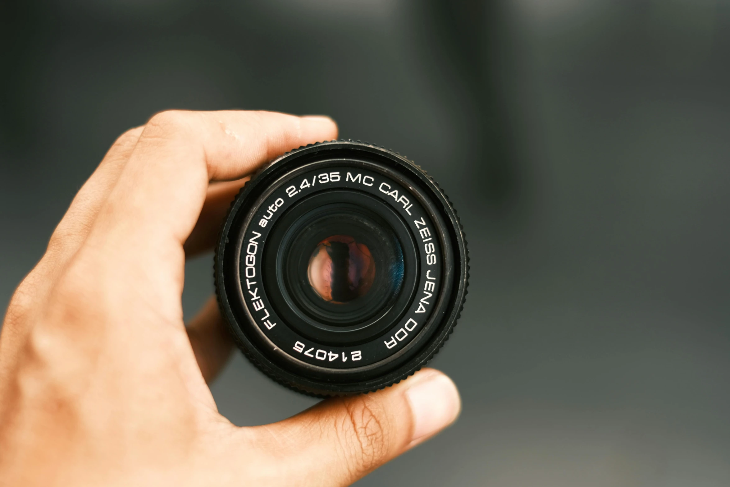 someone holds a camera lens in their hand