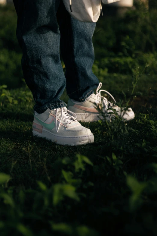 a person with sneakers that are white in the grass