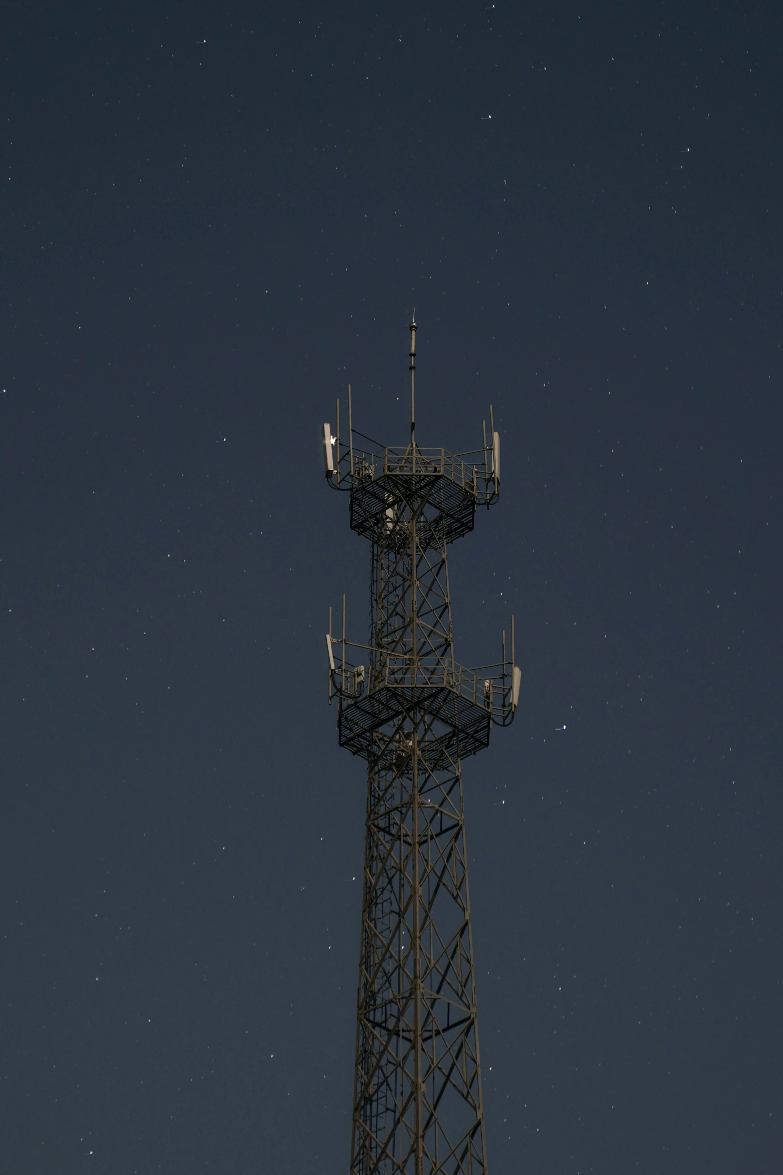 a radio tower is against the dark sky at night