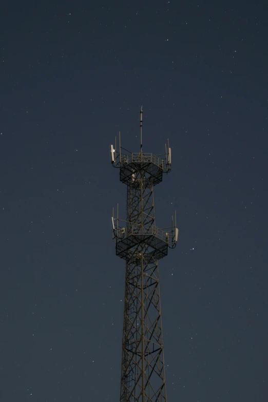 a radio tower is against the dark sky at night