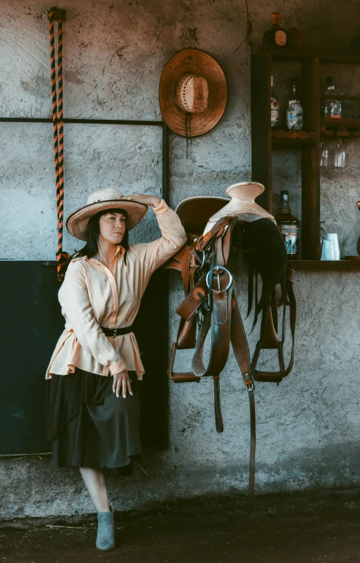 a woman poses next to a saddle for a po