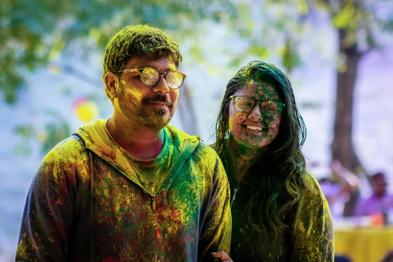 a woman with makeup is covered in color next to a man