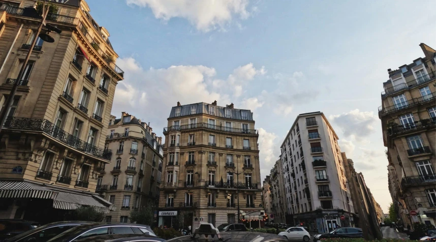 an urban street with high rise buildings, parking spaces and various vehicles on it