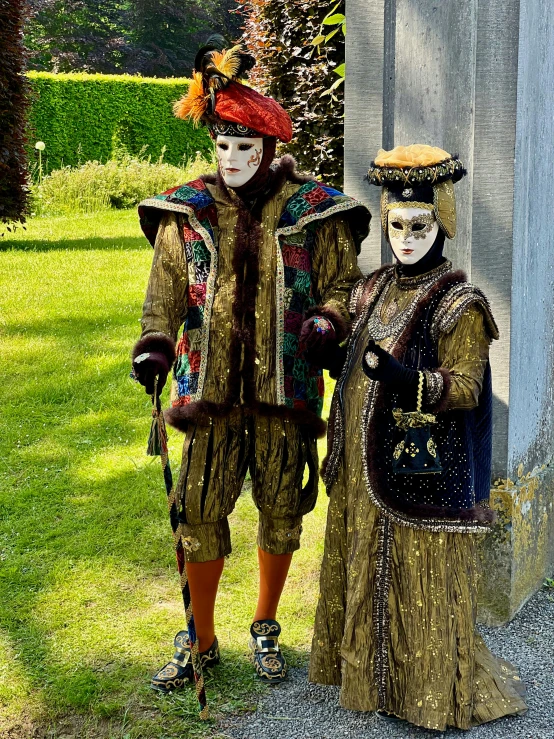 two people dressed in costumes and masks stand outside