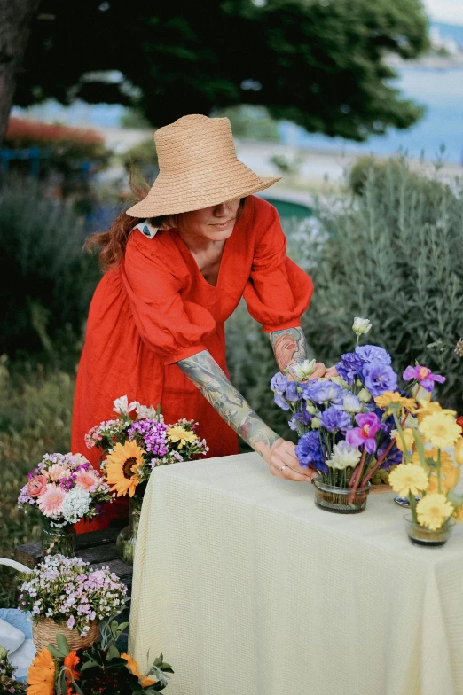 an older woman working with flowers on a table
