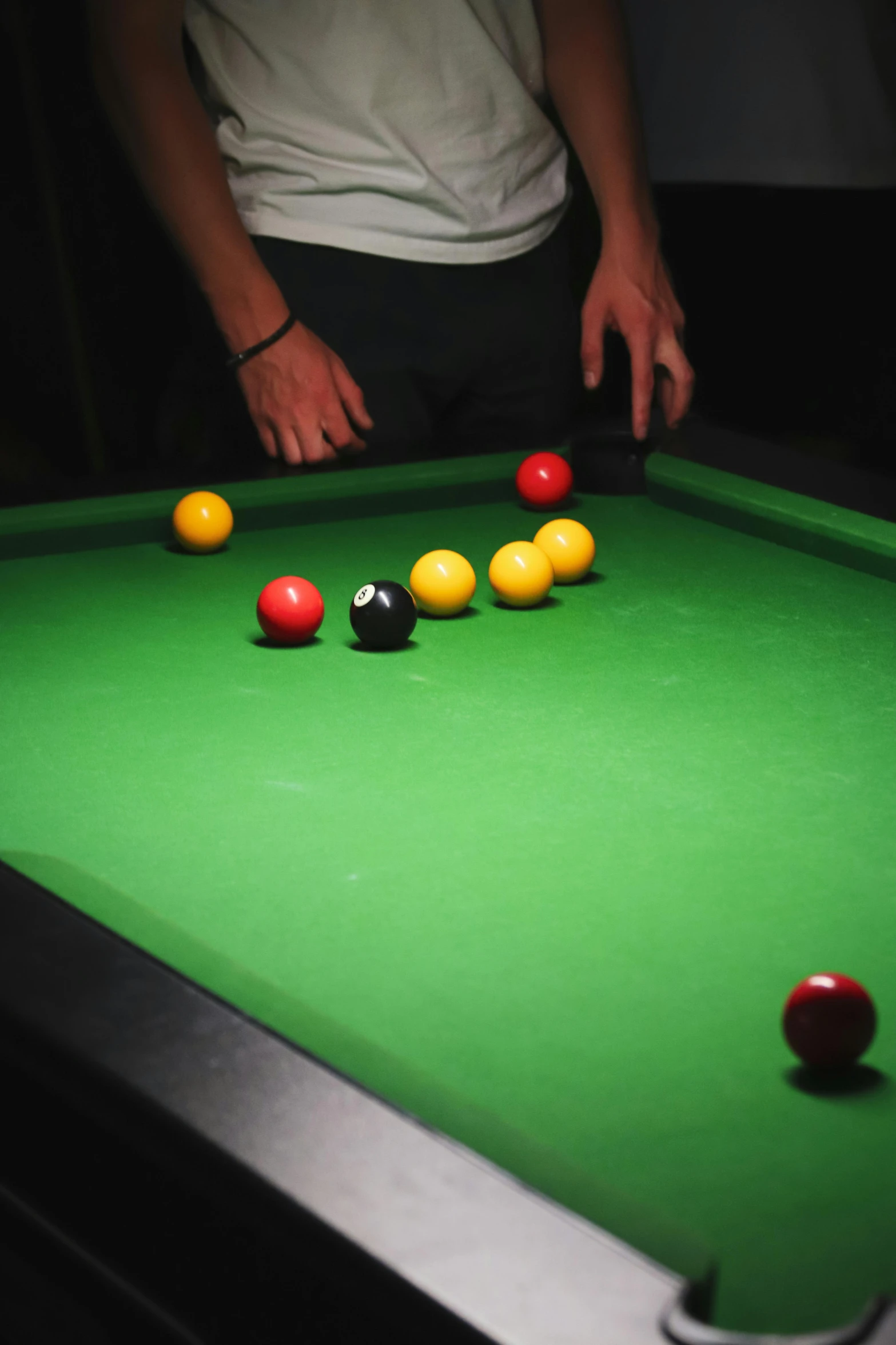 person holding a cue up to some billiards balls